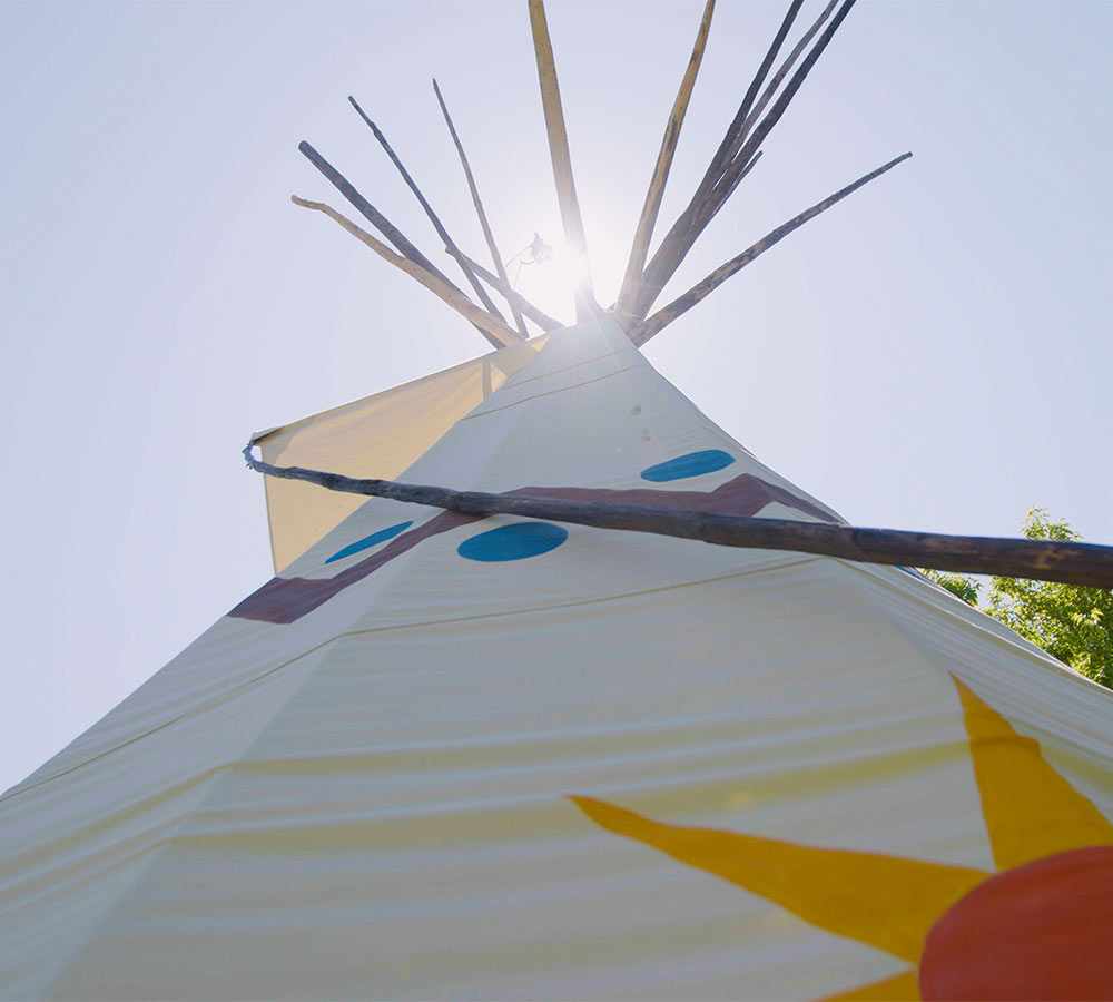 tipi with sun peaking behind