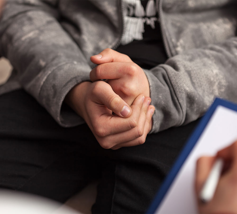 Young teenager boy at counseling - close up on hands