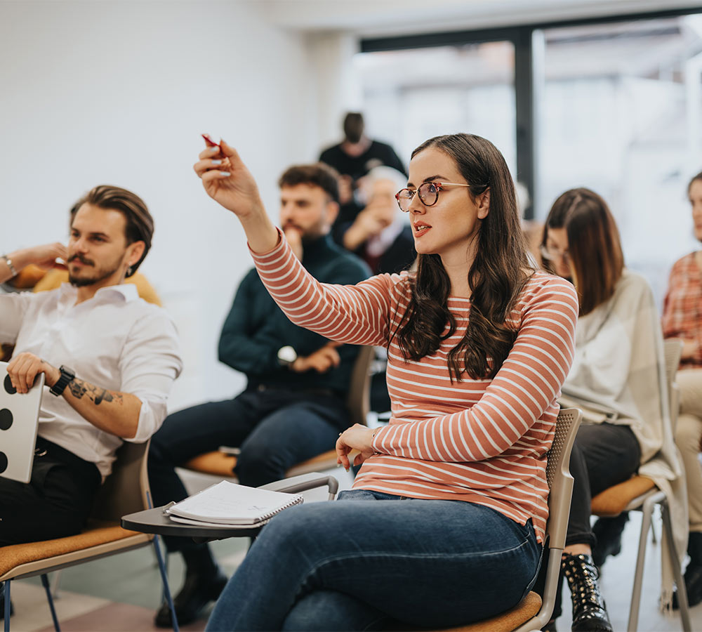 audience in an interactive workshop or business meeting raising hands